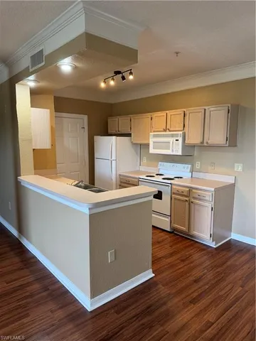 a kitchen with wooden floors and white stainless steel appliances