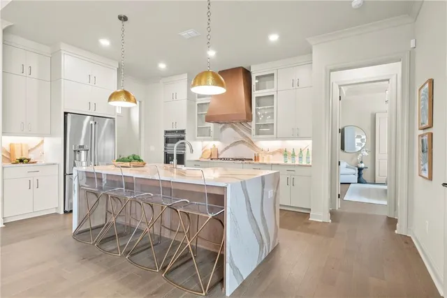 a kitchen with stainless steel appliances granite countertop a table chairs sink and wooden cabinets