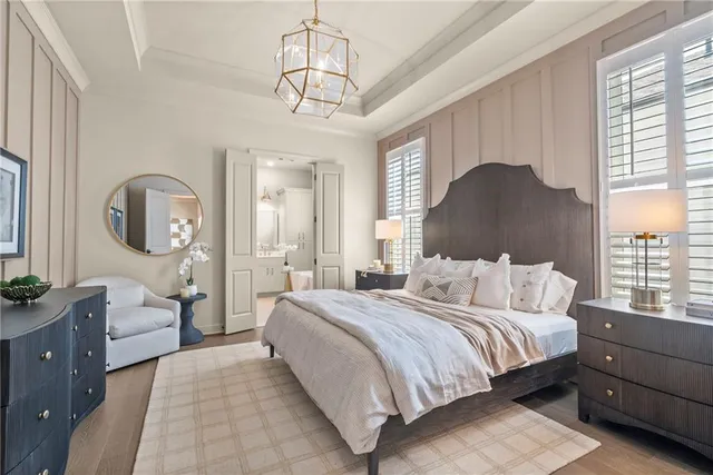 a bedroom with a large bed and a chandelier