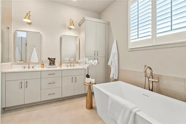 a bathroom with a double vanity sink mirror and next to a window