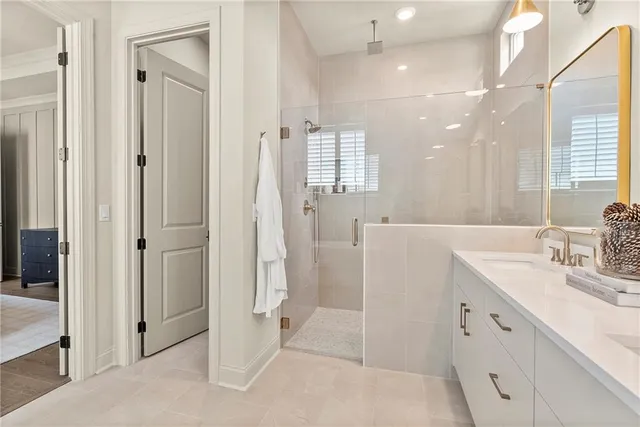 a bathroom with a double vanity sink a mirror and a shower