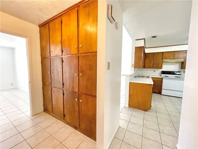 a view of kitchen with stainless steel appliances granite countertop a refrigerator and a stove top oven