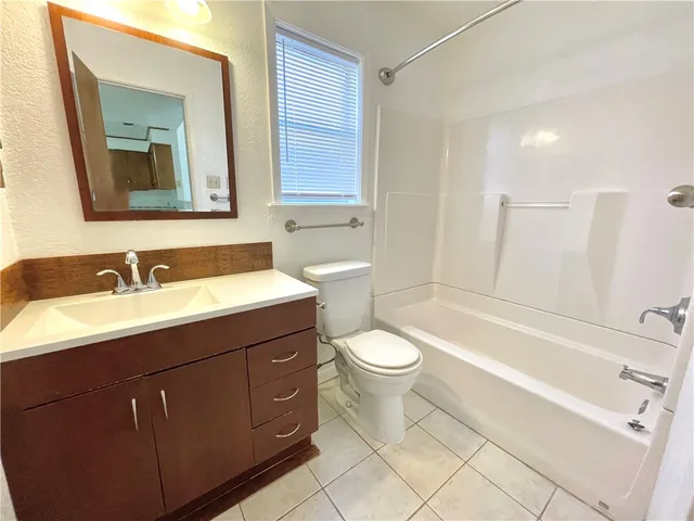 a bathroom with a toilet a sink a tub and mirror