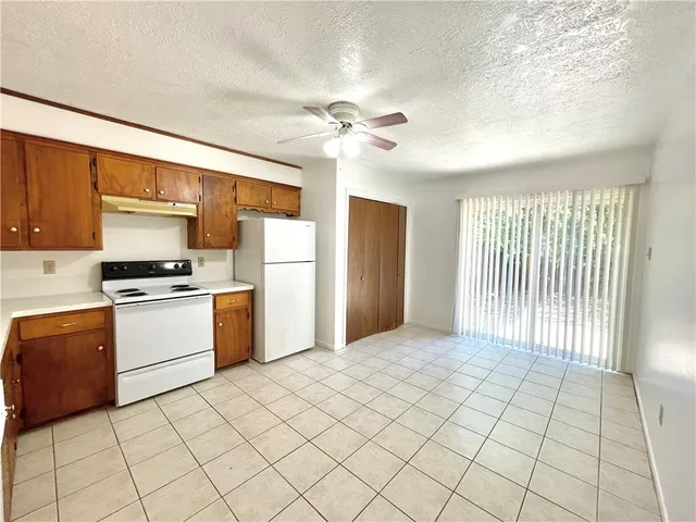 a kitchen with a stove a refrigerator and cabinets