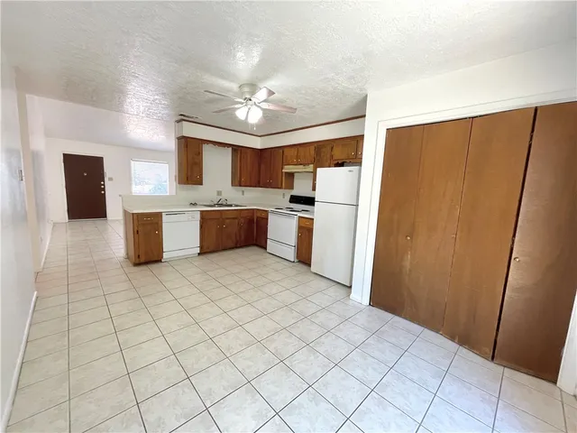 a large kitchen with a counter space a sink appliances and cabinets