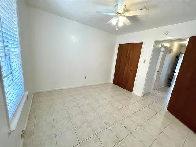 an empty room with closet and windows