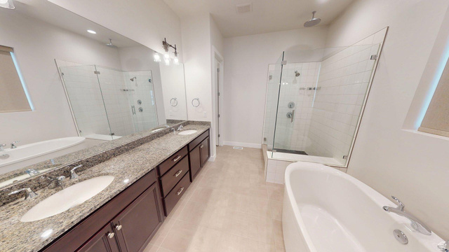 5502 North Valley View Road Lehi, UT 84048 - Photo 14 of 33 Spacious bathroom featuring a freestanding soaking tub, a frameless glass shower enclosure with subway tile surround, and a double vanity with stone countertops and undermount sinks