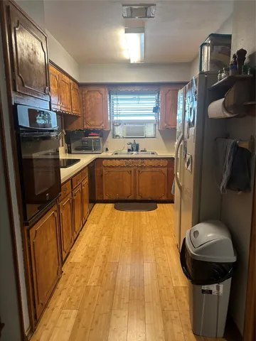 a kitchen with stainless steel appliances granite countertop a sink a stove and a wooden floors