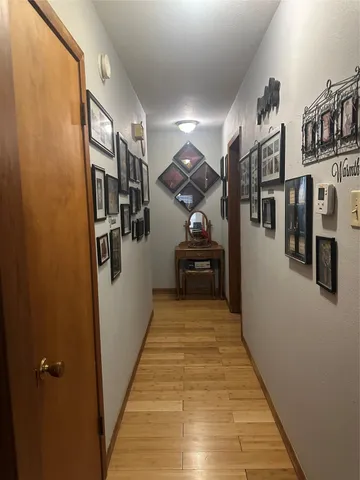 a view of a hallway with wooden floor and staircase