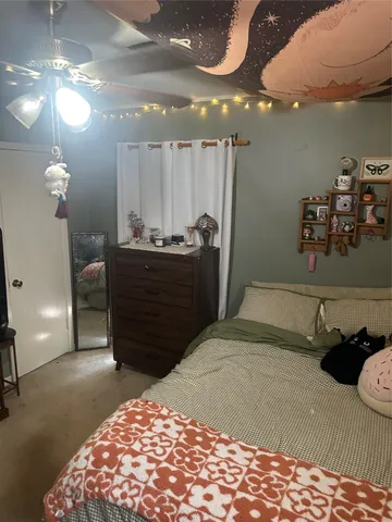a bed room with a bed mirror and a chandelier
