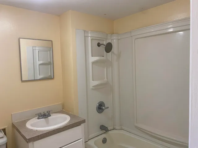 a bathroom with a sink a mirror and shower