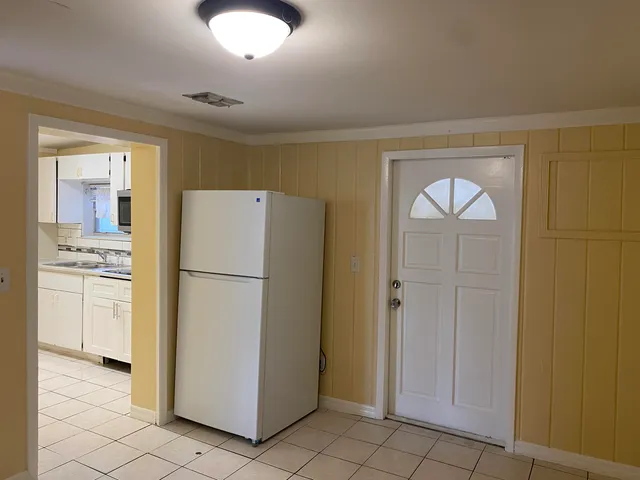 a white refrigerator freezer and a stove sitting inside of a kitchen