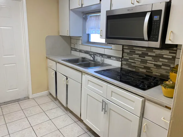 a kitchen with stainless steel appliances granite countertop a sink stove and microwave