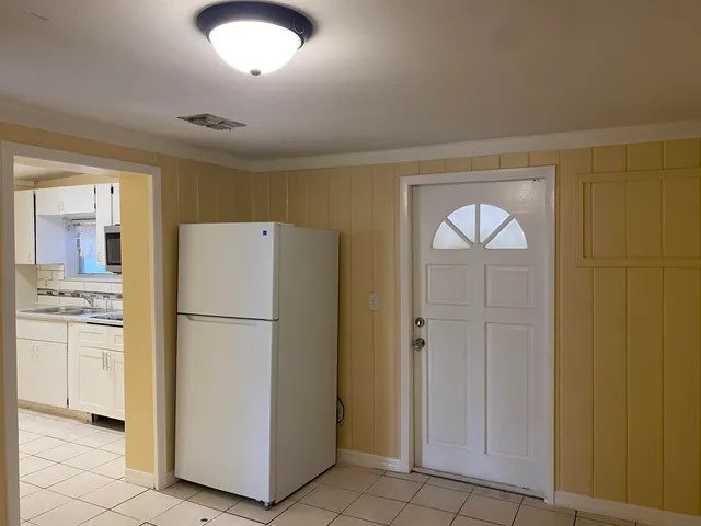 a white refrigerator freezer and a stove sitting inside of a kitchen