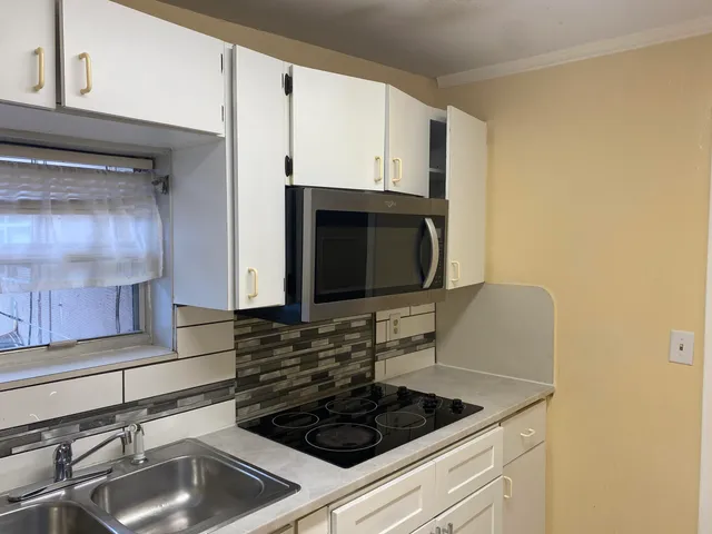 a kitchen with stainless steel appliances granite countertop a sink stove and microwave
