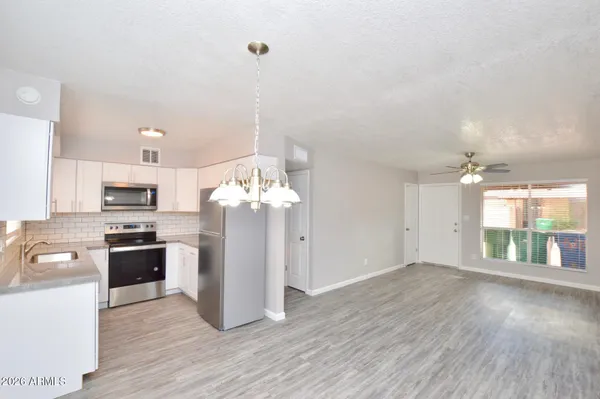 a large kitchen with cabinets wooden floor and stainless steel appliances