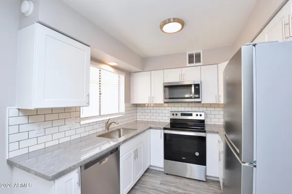 a kitchen with stainless steel appliances a stove sink microwave and refrigerator