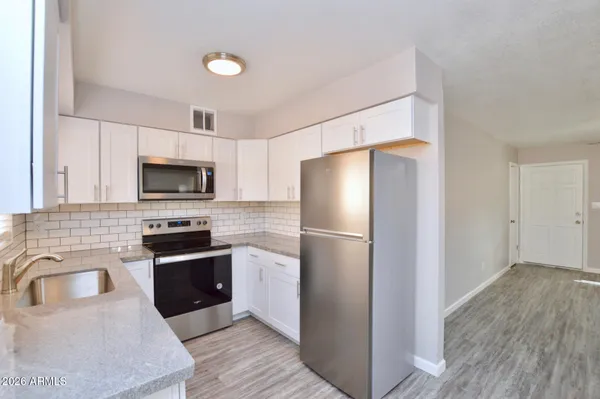 a kitchen with stainless steel appliances a refrigerator stove microwave and sink