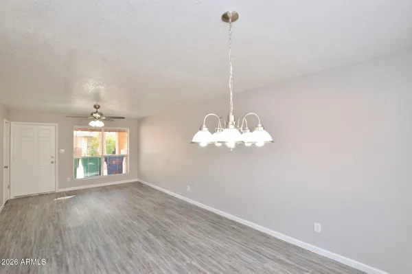 a view of a room with wooden floor and chandelier