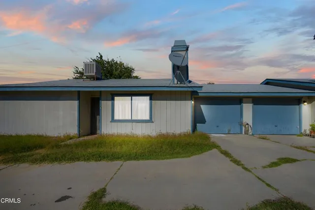 a front view of a house with a garden and yard