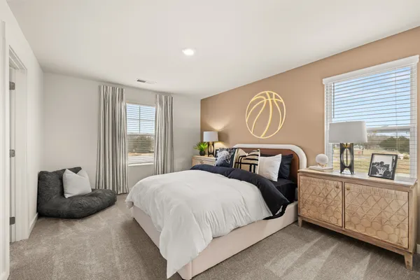 a bedroom with a bed and a large mirror next to a window