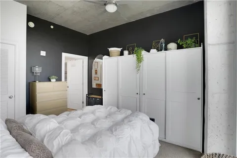a bedroom with a bed and a refrigerator