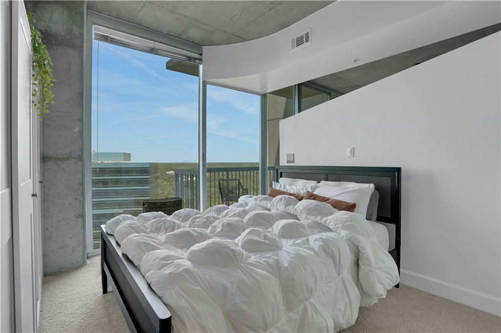 3300 Windy Ridge Parkway Southeast, Unit 1603 Atlanta, GA 30339 - Photo 15 of 36 a large bed sitting in a bedroom next to a window