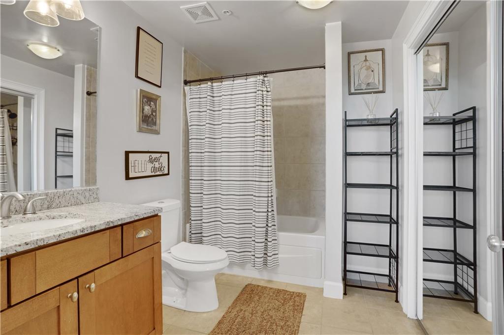 3300 Windy Ridge Parkway Southeast, Unit 1603 Atlanta, GA 30339 - Photo 16 of 36 a bathroom with a granite countertop sink toilet and shower