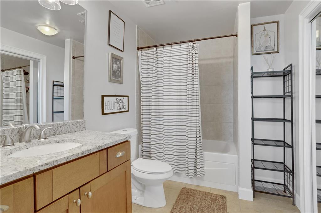 3300 Windy Ridge Parkway Southeast, Unit 1603 Atlanta, GA 30339 - Photo 17 of 36 a bathroom with a granite countertop sink toilet and shower