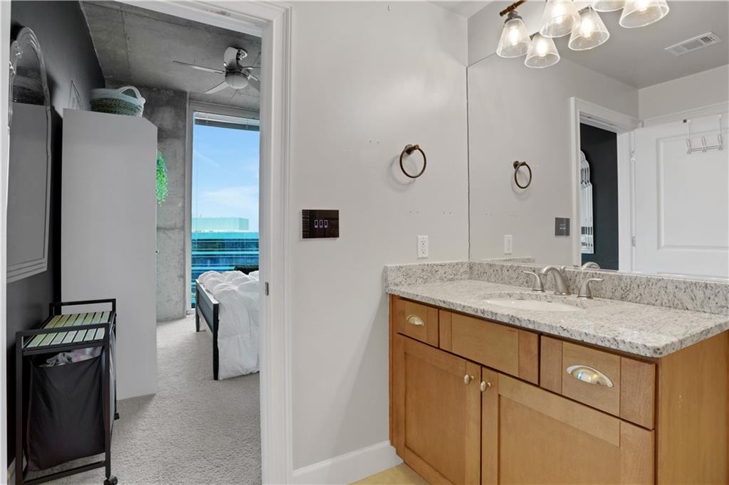 3300 Windy Ridge Parkway Southeast, Unit 1603 Atlanta, GA 30339 - Photo 18 of 36 a bathroom with a granite countertop sink a mirror and shower view