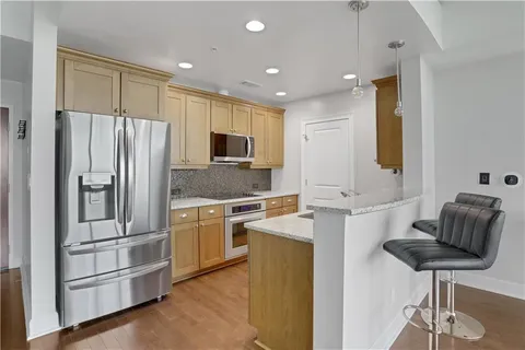 a kitchen with stainless steel appliances granite countertop a refrigerator and a sink