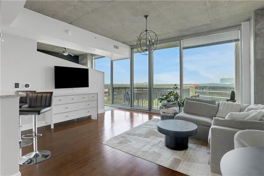 3300 Windy Ridge Parkway Southeast, Unit 1603 Atlanta, GA 30339 - Photo 10 of 36 a living room with couch a flat screen tv and floor to ceiling window