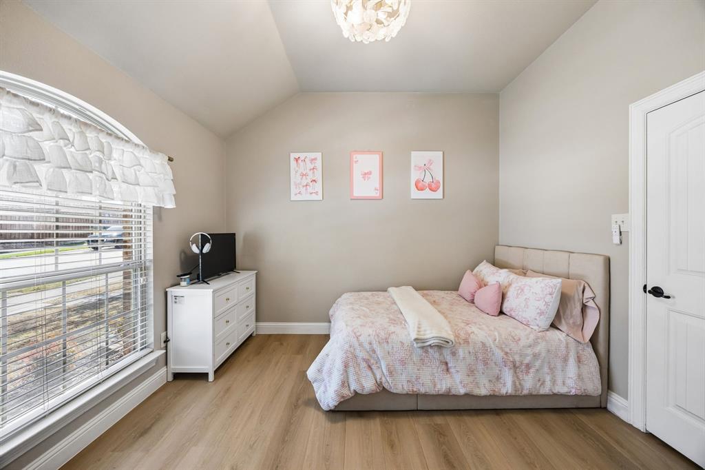 3917 Gatewick Drive Rockwall, TX 75087 - Photo 20 of 34 a bedroom with a bed and wooden floor