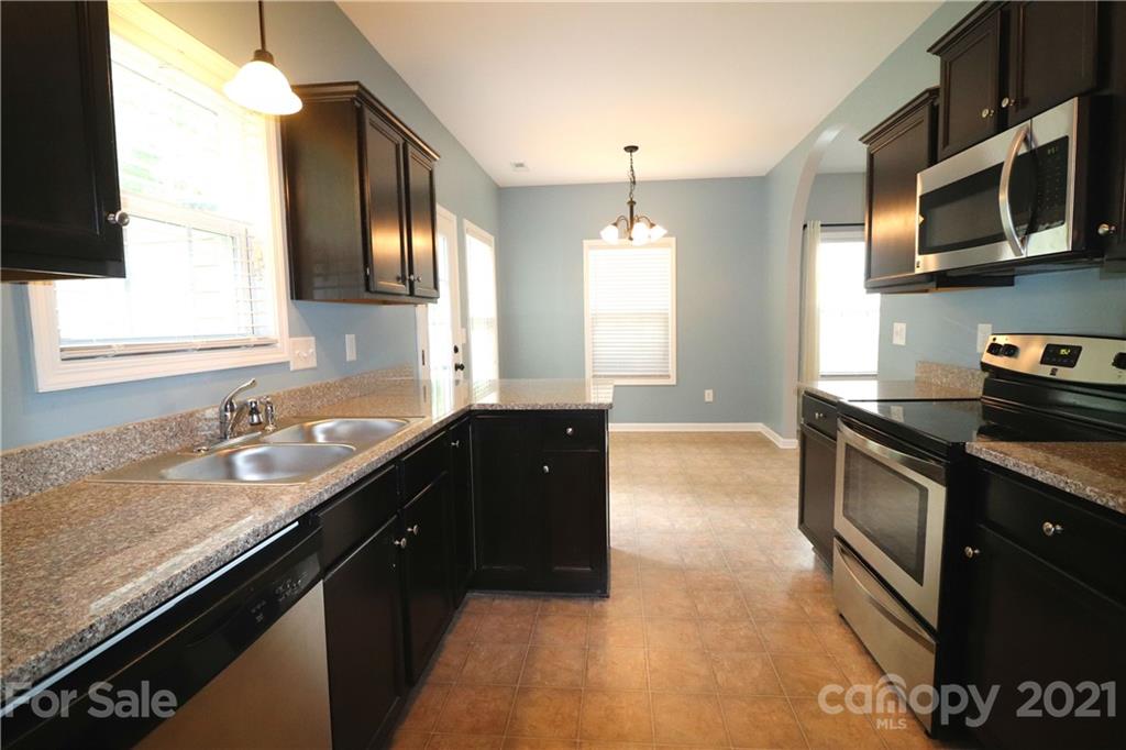 440 Danielle Way Fort Mill, SC 29715 - Photo 5 of 19 a kitchen with granite countertop stainless steel appliances a sink stove top oven and cabinets