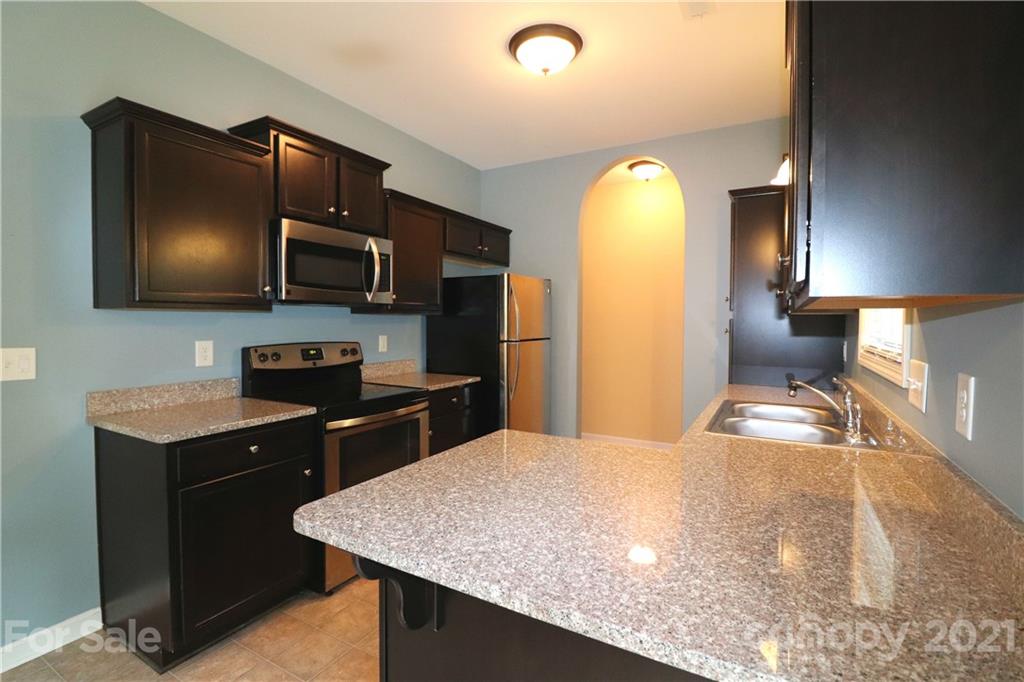 440 Danielle Way Fort Mill, SC 29715 - Photo 6 of 19 a kitchen with kitchen island granite countertop cabinets and black appliances