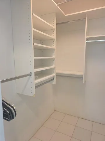 a view of walk in closet with empty racks