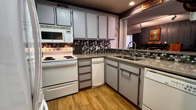 a kitchen with white cabinets stainless steel appliances and a sink