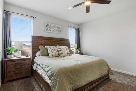 a bedroom with a bed and a potted plant on the dresser