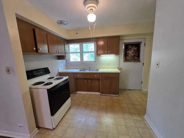 a kitchen with a stove sink and cabinets