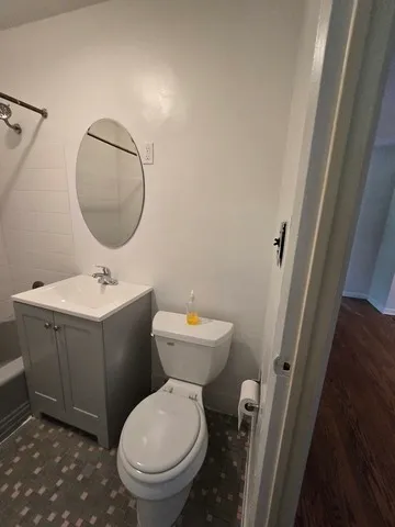 a bathroom with a toilet sink and mirror