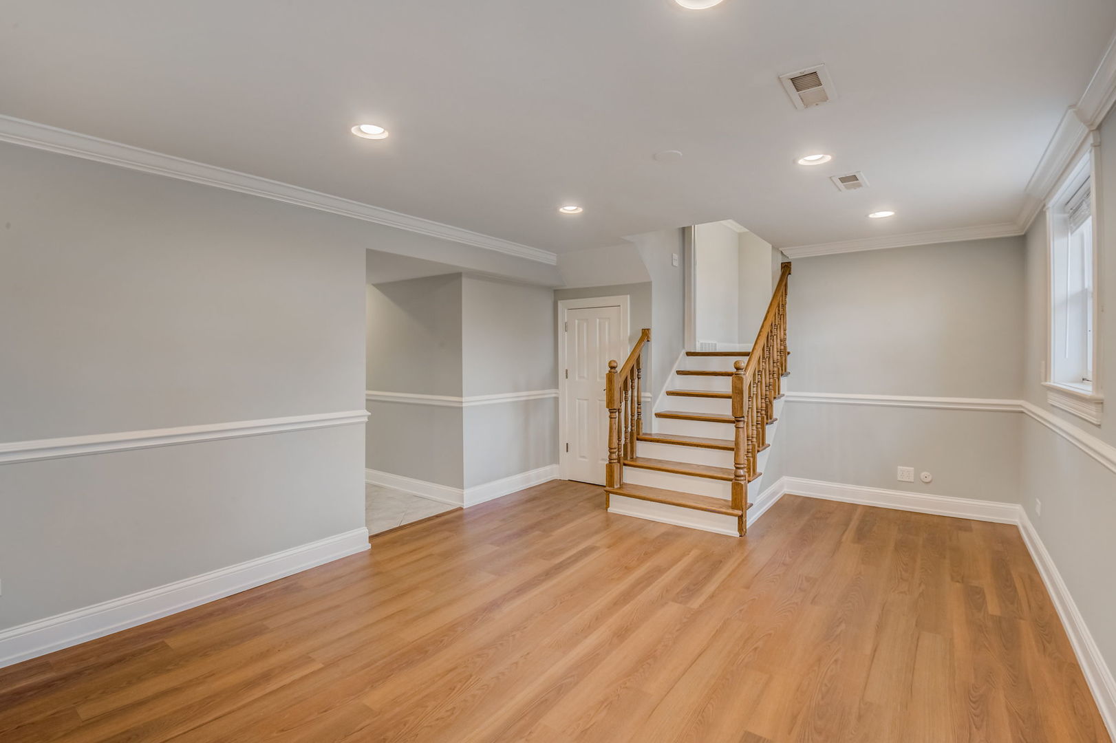 1673 East Algonquin Road Des Plaines, IL 60016 - Photo 14 of 36 a view of an empty room with wooden floor stairs and a bathroom