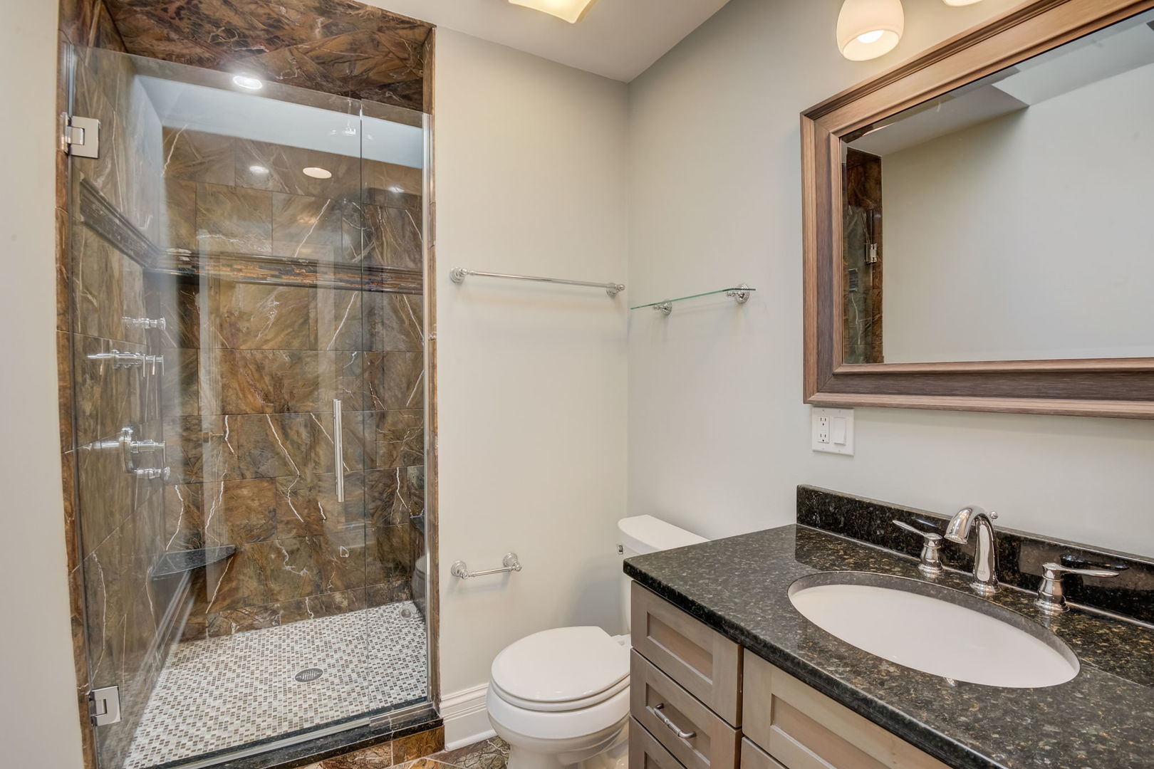 1673 East Algonquin Road Des Plaines, IL 60016 - Photo 20 of 36 a bathroom with a granite countertop sink toilet a mirror and shower