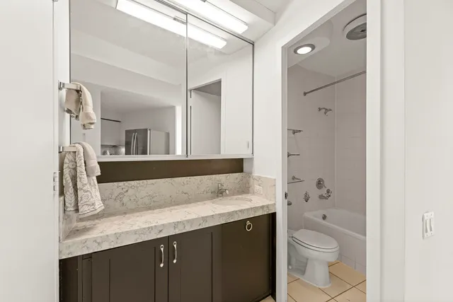 a bathroom with a granite countertop sink toilet and shower