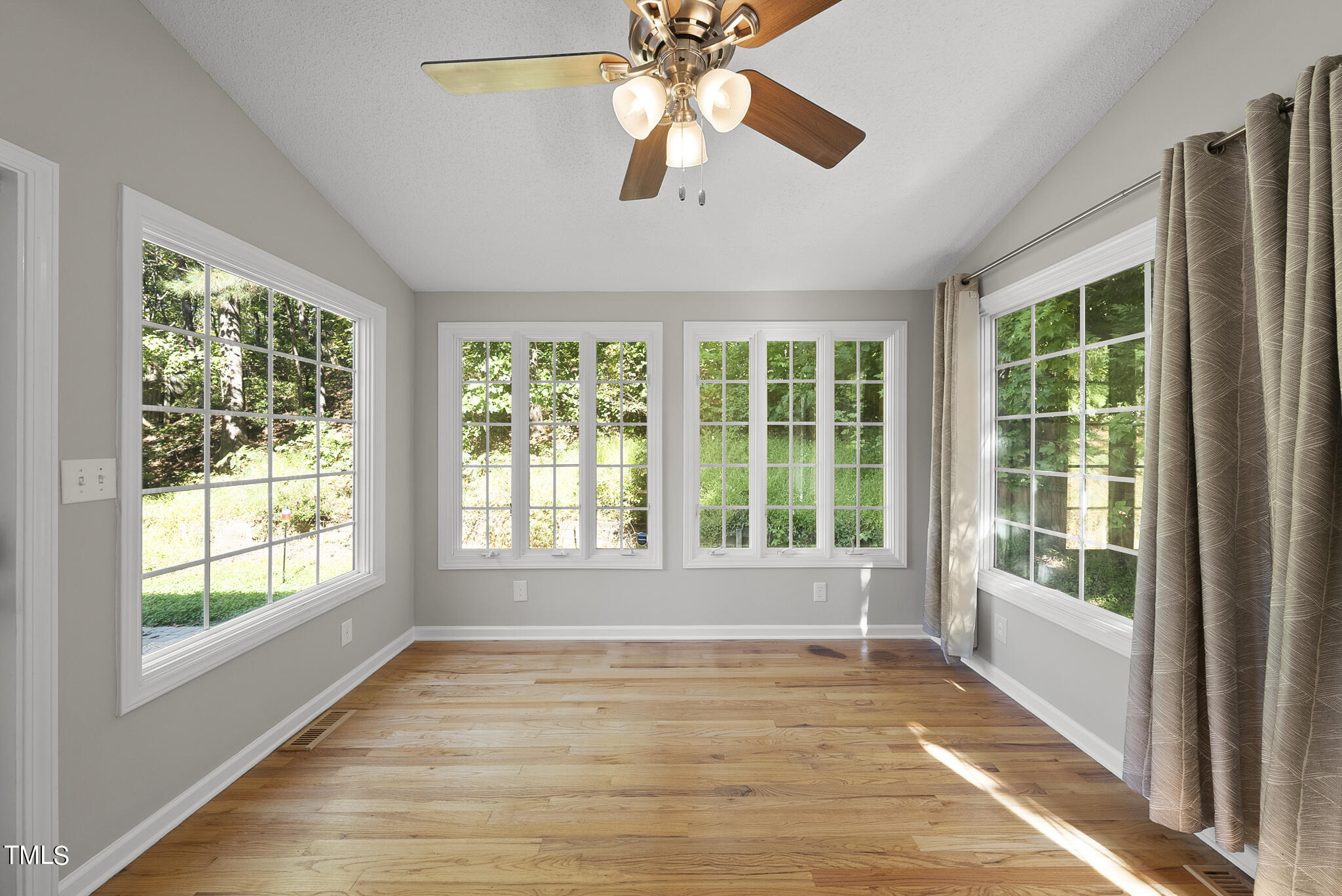 6709 Holly Mill Court Raleigh, NC 27613 - Photo 13 of 36 a view of an empty room with a window and wooden floor