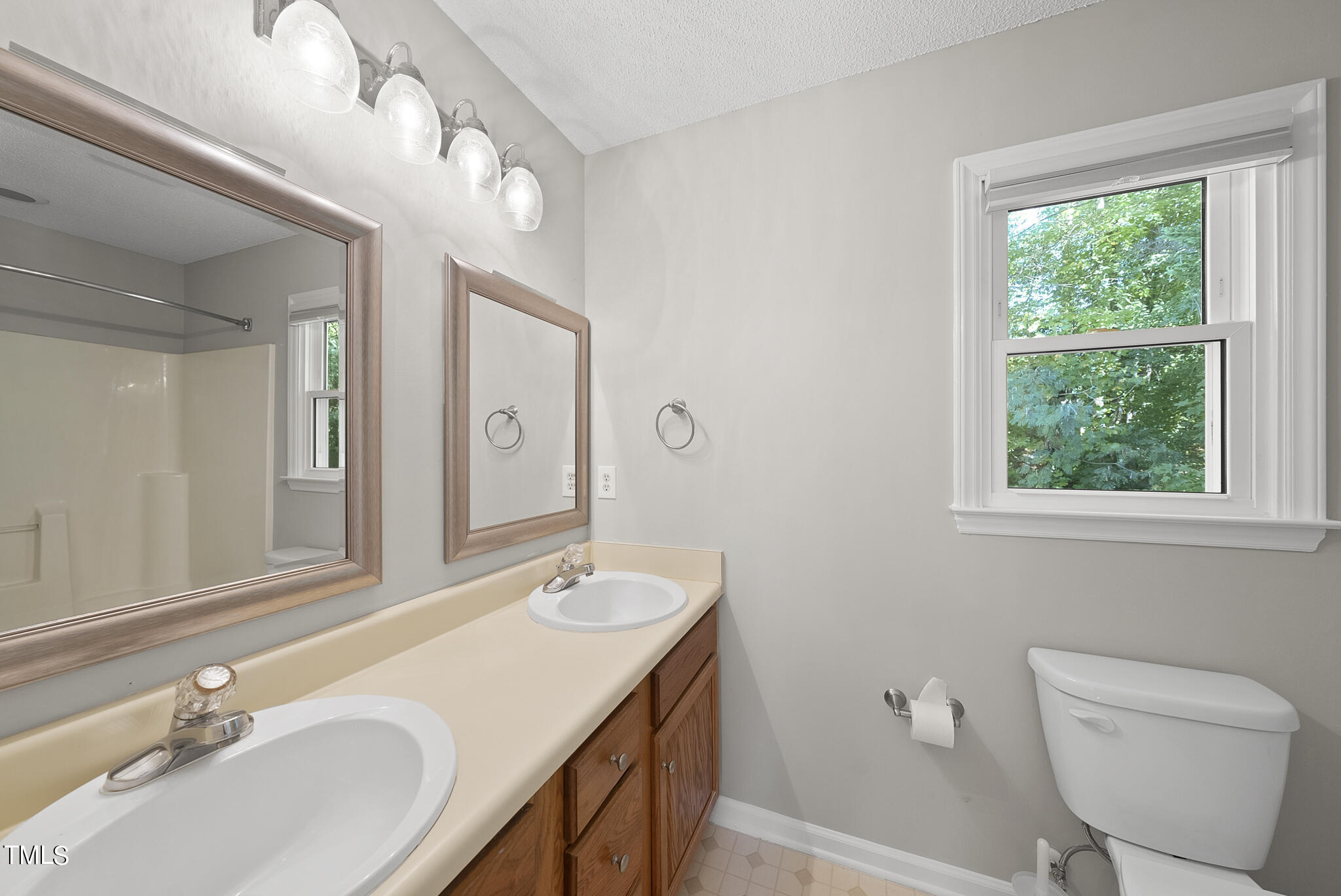 6709 Holly Mill Court Raleigh, NC 27613 - Photo 21 of 36 a bathroom with a double vanity sink toilet and a mirror