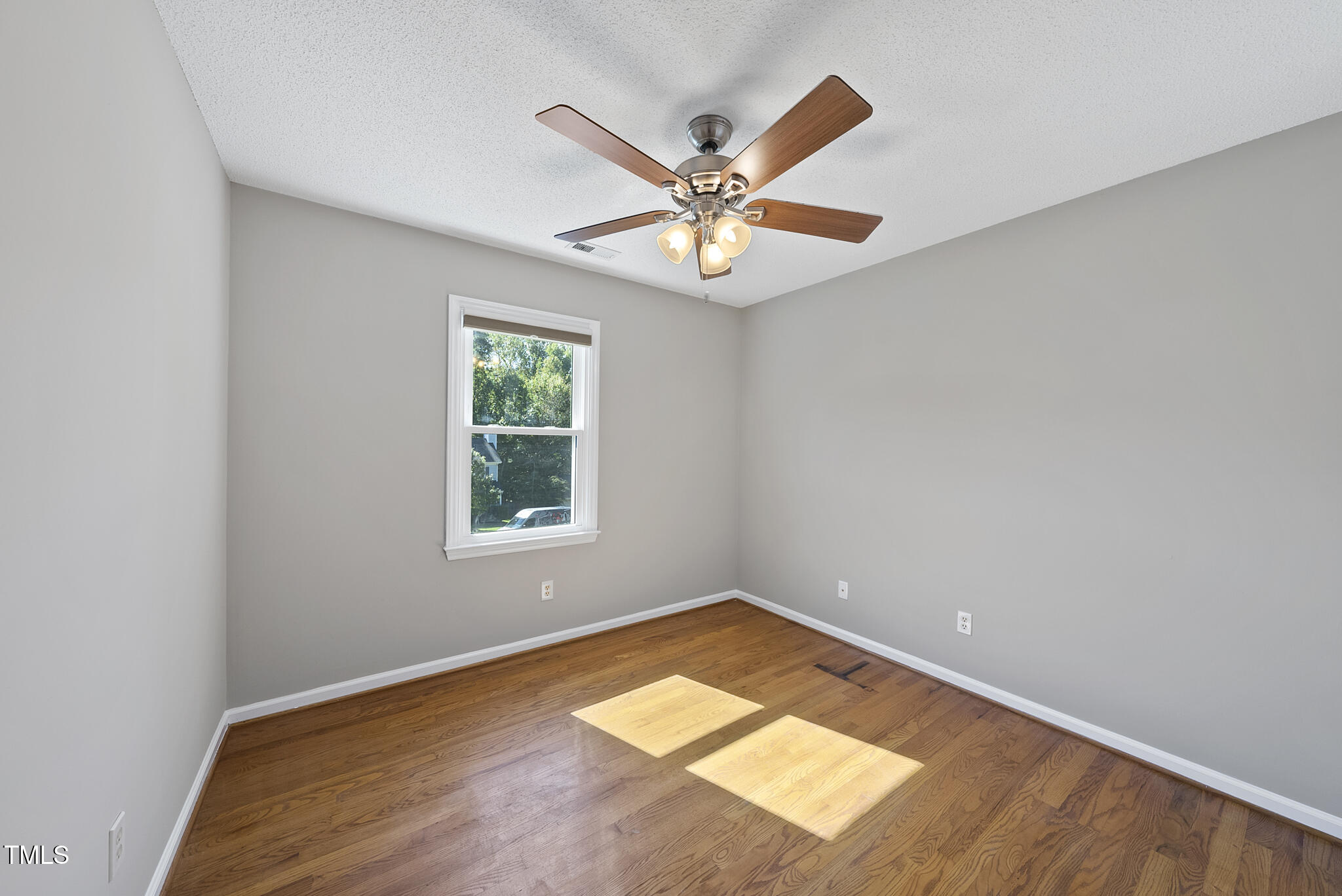6709 Holly Mill Court Raleigh, NC 27613 - Photo 27 of 36 an empty room with wooden floor chandelier fan and windows