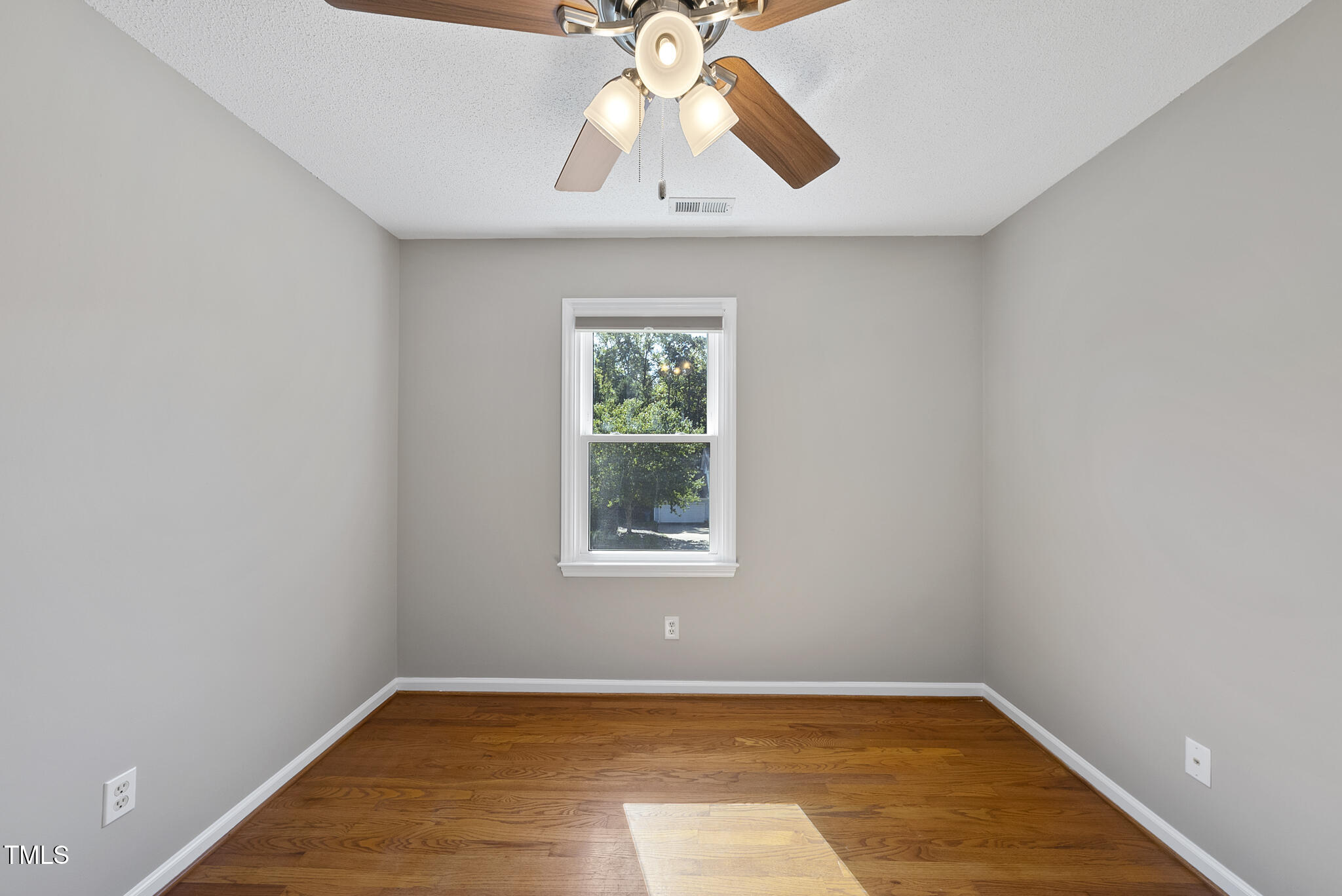 6709 Holly Mill Court Raleigh, NC 27613 - Photo 28 of 36 an empty room with a window and wooden floor