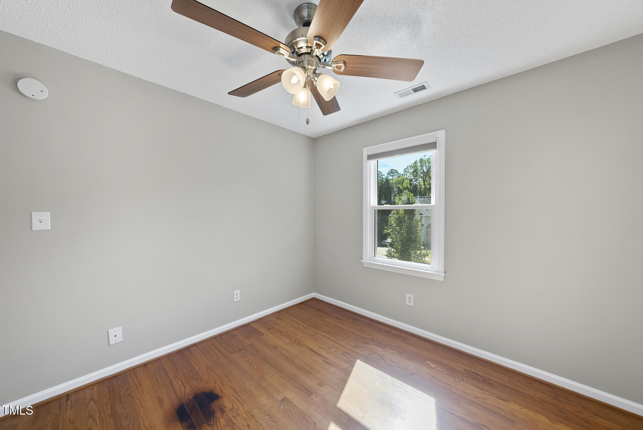 6709 Holly Mill Court Raleigh, NC 27613 - Photo 29 of 36 an empty room with a window and a ceiling fan