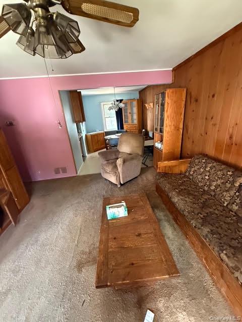 35 Marlow Road Valley Stream, NY 11580 - Photo 15 of 19 Living room featuring wooden walls, carpet, and a ceiling fan