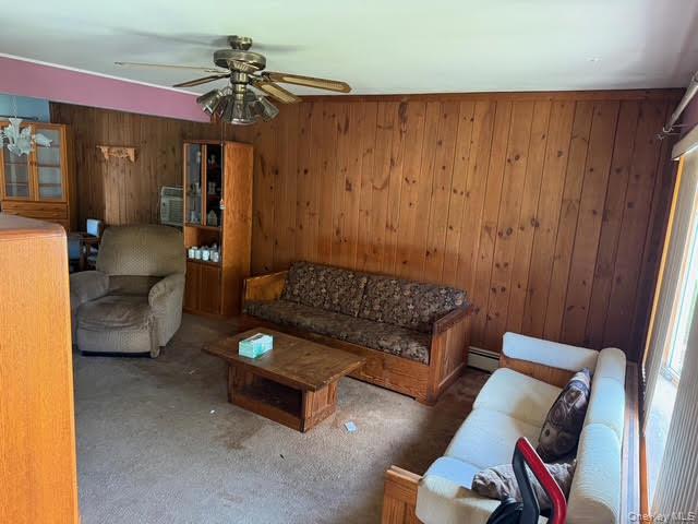 35 Marlow Road Valley Stream, NY 11580 - Photo 16 of 19 Carpeted living area featuring wooden walls and a ceiling fan